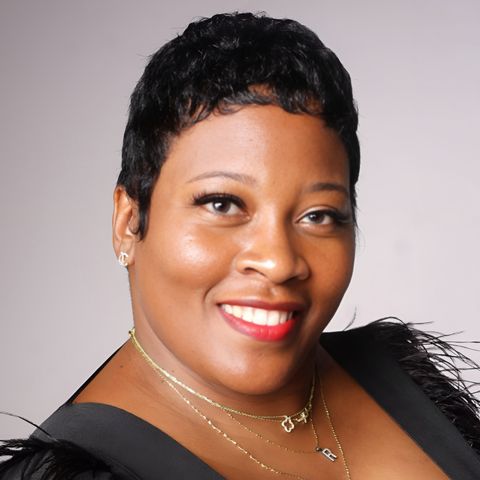 Ro — owner of DiVine Stylez — studio portrait in a black feather-trimmed gown